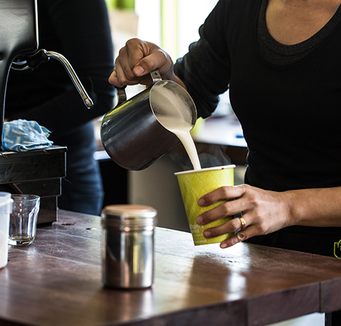 Pouring milk into takeaway coffee cup